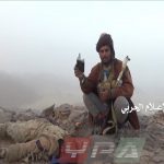 قتيل ثالث من قوات التحالف بجواره احد افراد الجيش اليمني يشاهد هوية القتيل في جبهة المهاشمة بمحافظة الجوف