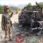 آلية محترقة لقوات التحالف بجوارها فرد من الجيش اليمني في جبهة المهاشمة محافظة الجوف
