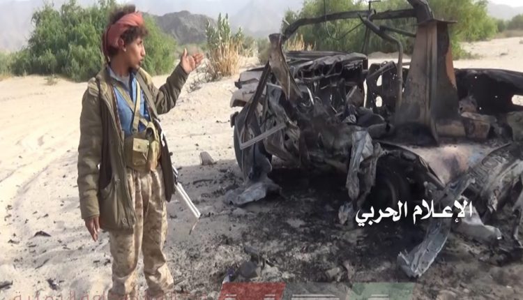 آلية محترقة لقوات التحالف بجوارها فرد من الجيش اليمني في جبهة المهاشمة محافظة الجوف